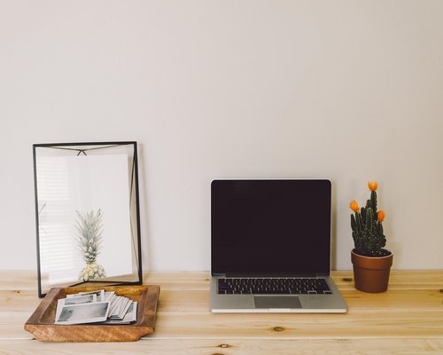 Ergonomic laptop setup on a wooden dining table in a Costa Rican home